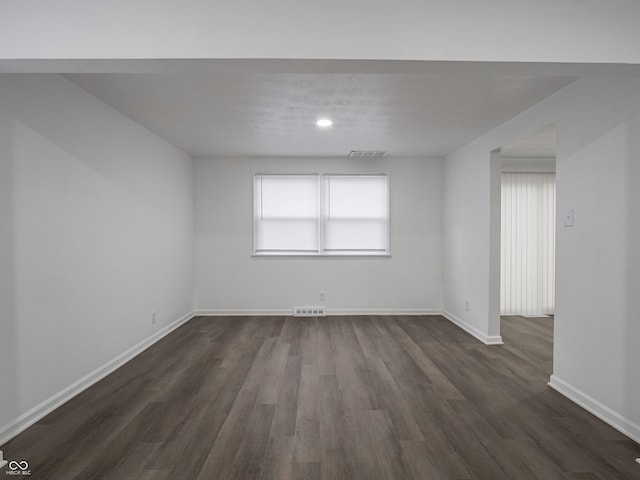 spare room featuring plenty of natural light and dark hardwood / wood-style flooring