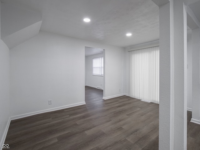 interior space featuring dark wood-type flooring and vaulted ceiling