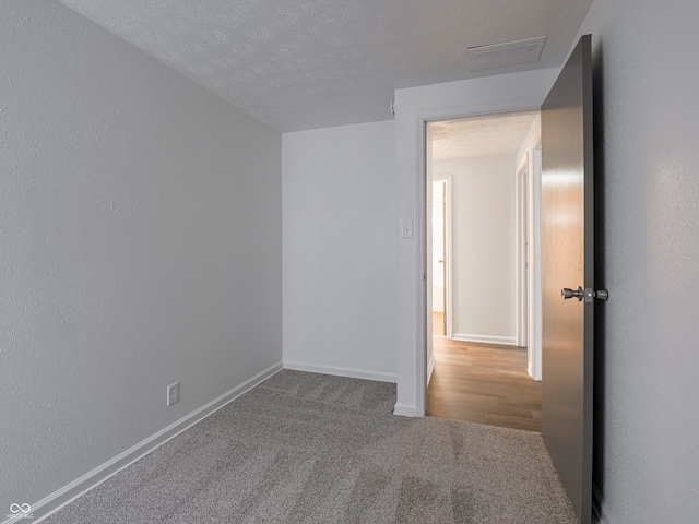 unfurnished room featuring carpet floors and a textured ceiling