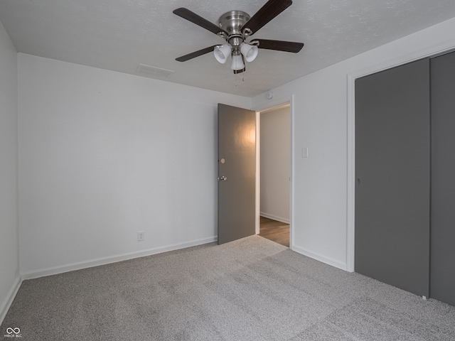 unfurnished bedroom with ceiling fan, a closet, and light carpet