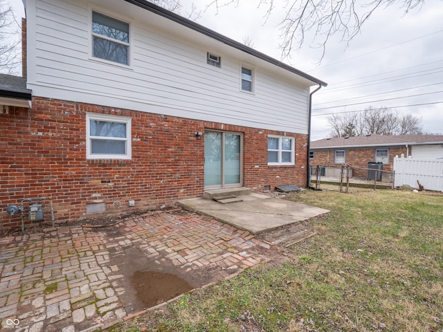 back of house featuring central air condition unit, a patio area, and a yard