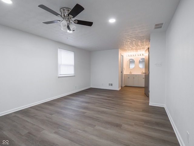 unfurnished bedroom featuring hardwood / wood-style floors, ensuite bathroom, and ceiling fan