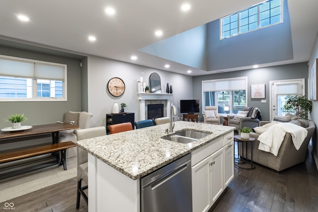 kitchen with a center island with sink, sink, stainless steel dishwasher, dark hardwood / wood-style floors, and white cabinetry