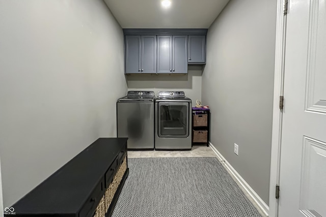 clothes washing area featuring cabinets and independent washer and dryer