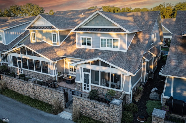 back house at dusk with a sunroom