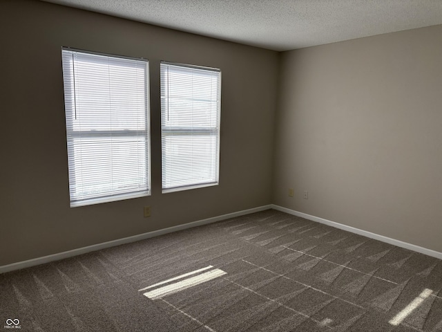 carpeted empty room featuring a textured ceiling