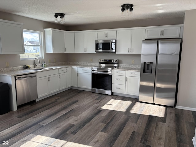 kitchen featuring white cabinetry, sink, stainless steel appliances, and dark hardwood / wood-style floors