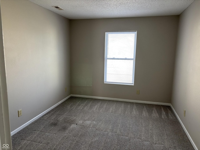 carpeted spare room with a textured ceiling