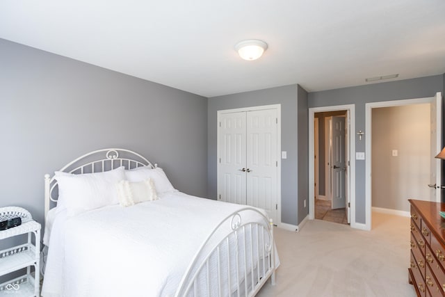 bedroom featuring light colored carpet and a closet