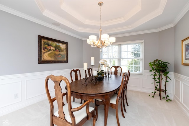 carpeted dining room with a chandelier and a raised ceiling