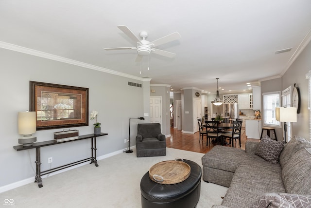 living room with ornamental molding and ceiling fan