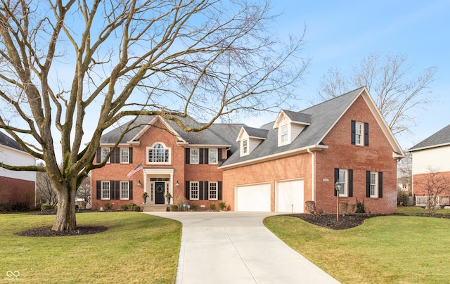 colonial inspired home with a garage and a front lawn