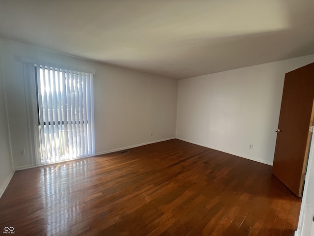 unfurnished room featuring dark wood-type flooring