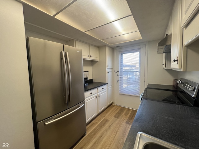 kitchen with ventilation hood, stainless steel fridge, range with electric stovetop, light hardwood / wood-style floors, and white cabinetry