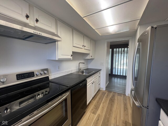 kitchen with sink, white cabinetry, stainless steel appliances, and light hardwood / wood-style flooring