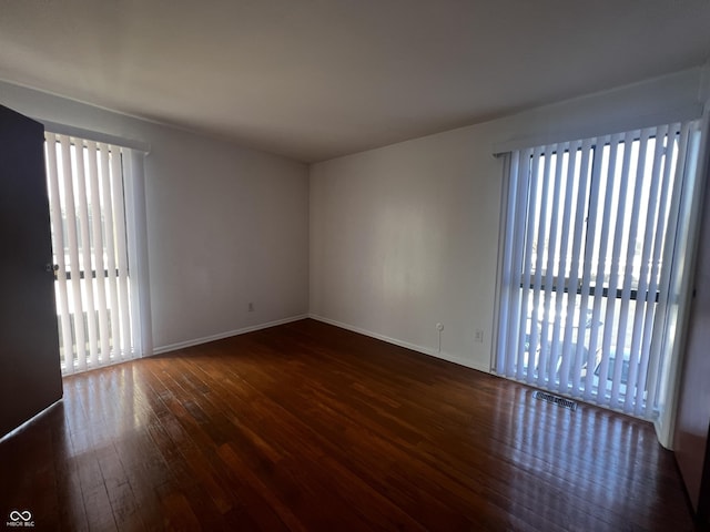 spare room with dark wood-type flooring