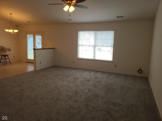 carpeted empty room with ceiling fan with notable chandelier