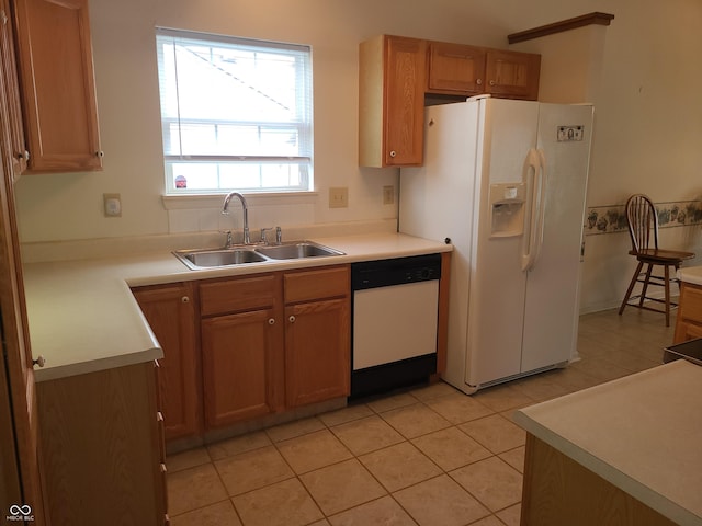 kitchen with sink, light tile patterned floors, and white appliances