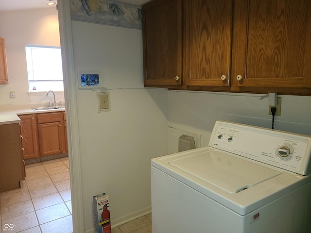 washroom with light tile patterned flooring, washer / dryer, and sink