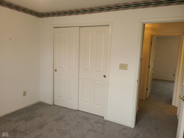 unfurnished bedroom featuring crown molding, a closet, and carpet floors