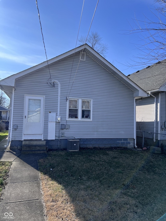 rear view of house with a lawn and cooling unit