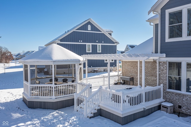 snow covered rear of property with a wooden deck