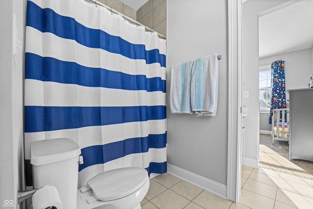 bathroom with tile patterned floors, walk in shower, and toilet