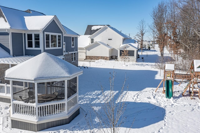 snow covered property with a playground