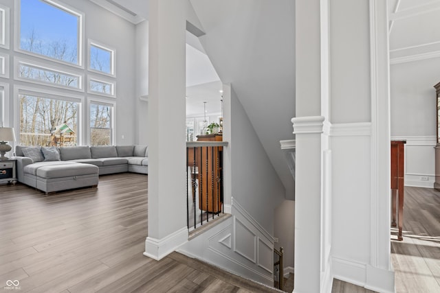 staircase featuring wood finished floors, baseboards, and a towering ceiling