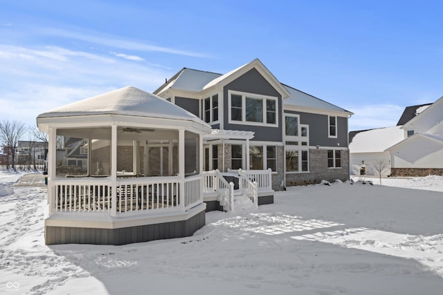 snow covered property featuring a sunroom