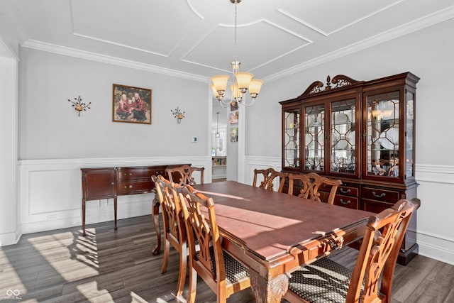 dining space featuring wainscoting, a notable chandelier, wood finished floors, and crown molding