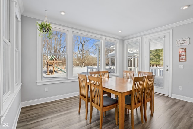 dining space featuring dark hardwood / wood-style floors, a wealth of natural light, and ornamental molding