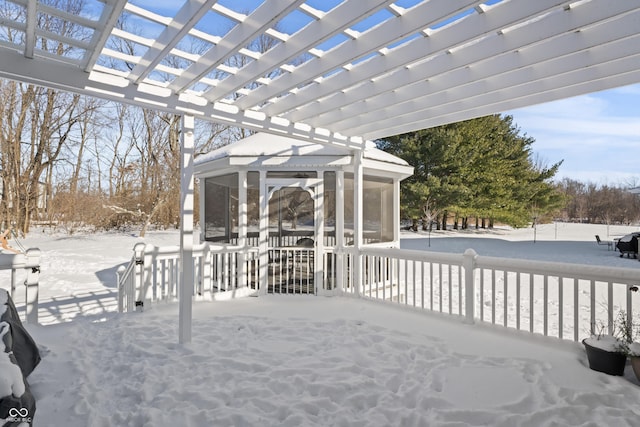 snow covered deck with a pergola and a sunroom