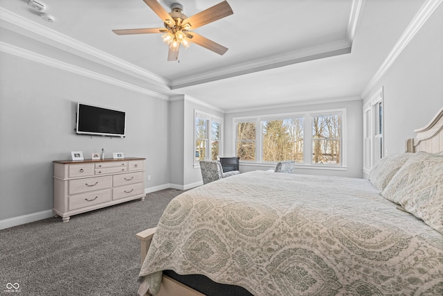 carpeted bedroom with baseboards, a ceiling fan, a tray ceiling, and ornamental molding