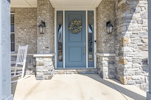 entrance to property featuring stone siding and covered porch