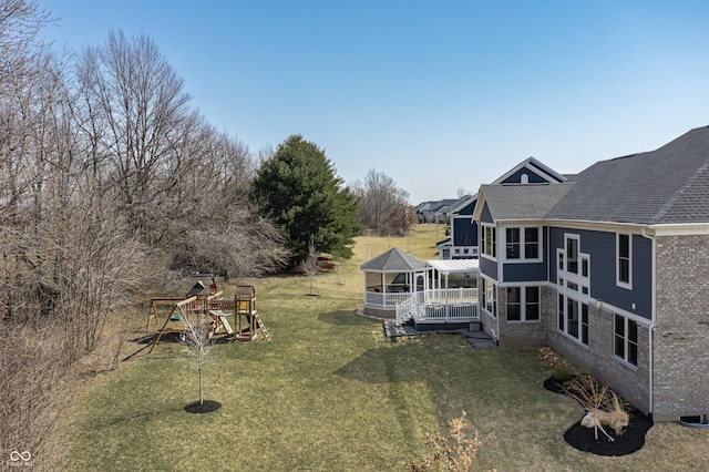 exterior space featuring a playground, a deck, and a sunroom