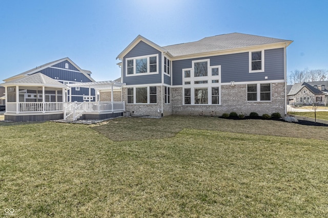 back of house featuring a sunroom, brick siding, a deck, and a pergola