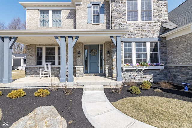 property entrance featuring stone siding and covered porch