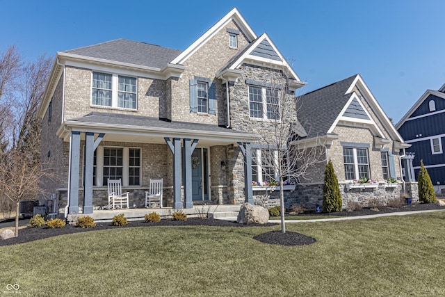 craftsman-style home featuring stone siding, covered porch, and a front lawn