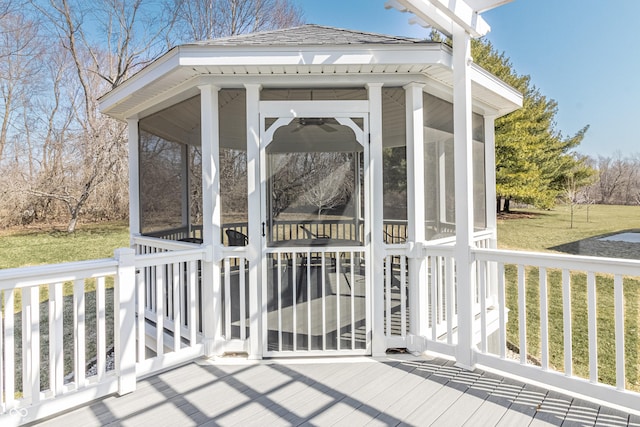 wooden deck with a yard and a sunroom