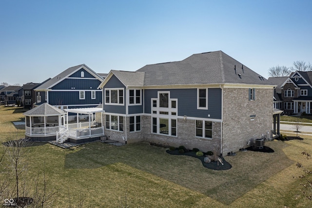 back of property with a gazebo, a lawn, central AC, and a wooden deck