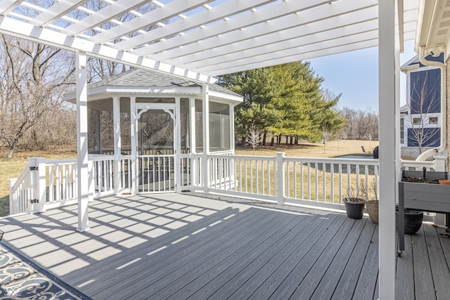 wooden deck featuring a pergola and a sunroom