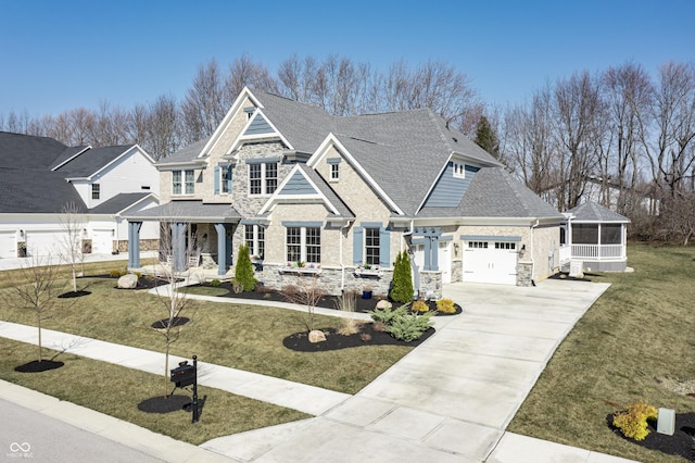 view of front facade featuring driveway, a porch, a sunroom, a garage, and stone siding