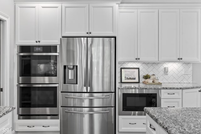 78 Chatham Brook Dr, Westfield, IN 46074 - kitchen with appliances with stainless steel finishes, white cabinets, backsplash, and light stone counters