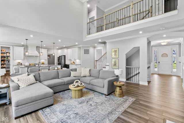 78 Chatham Brook Dr, Westfield, IN 46074 - living area with wood finished floors, crown molding, stairs, a high ceiling, and recessed lighting