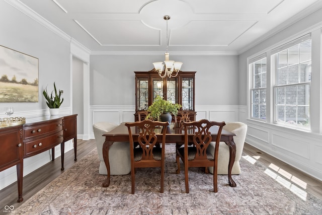 78 Chatham Brook Dr, Westfield, IN 46074 - dining space with a chandelier, wood finished floors, a wainscoted wall, crown molding, and a decorative wall