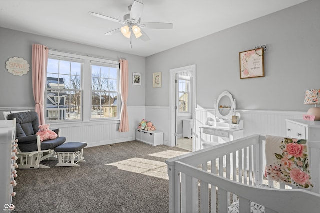 78 Chatham Brook Dr, Westfield, IN 46074 - carpeted bedroom with a wainscoted wall, a nursery area, multiple windows, and a ceiling fan