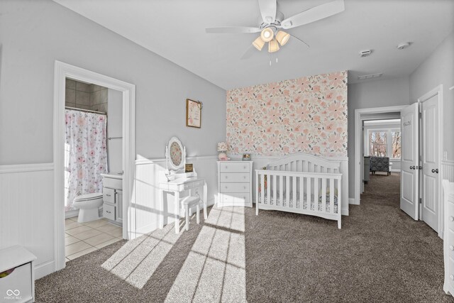 78 Chatham Brook Dr, Westfield, IN 46074 - tiled bedroom with wainscoting, a nursery area, carpet flooring, a ceiling fan, and connected bathroom