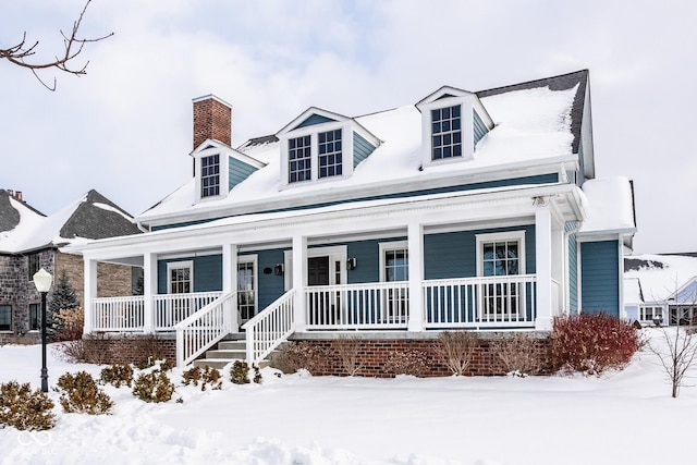 cape cod home featuring covered porch