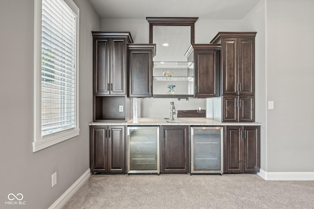 bar featuring wine cooler, a healthy amount of sunlight, and light carpet